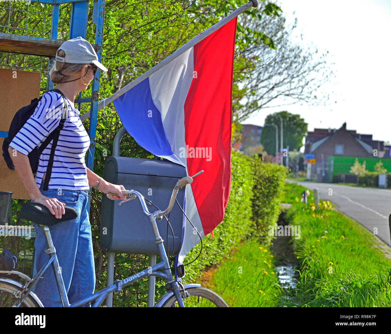 Woman standing with location en face de pavillon néerlandais en pleine campagne à Rijnsburg, Hollande, Pays-Bas Banque D'Images