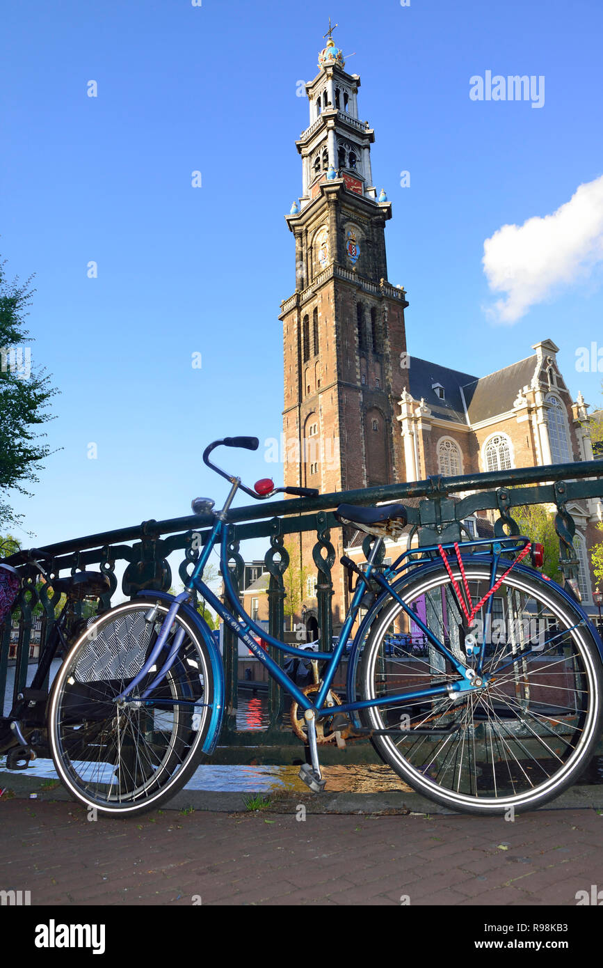 Vélos hollandais parqués pour pont, avec la célèbre église Westerkerk dans l'arrière-plan dans la capitale d'Amsterdam, Hollande, Pays-Bas Banque D'Images