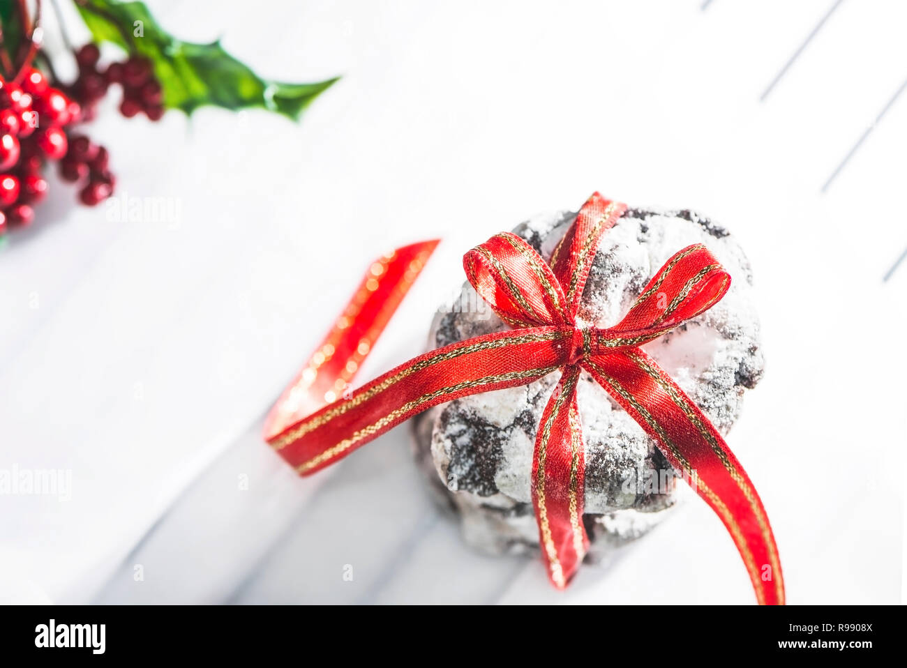 Yummy chocolate crinkle biscuits avec ruban rouge sur fond blanc du papier sulfurisé, Close up. Maison de vacances photographie concept Banque D'Images