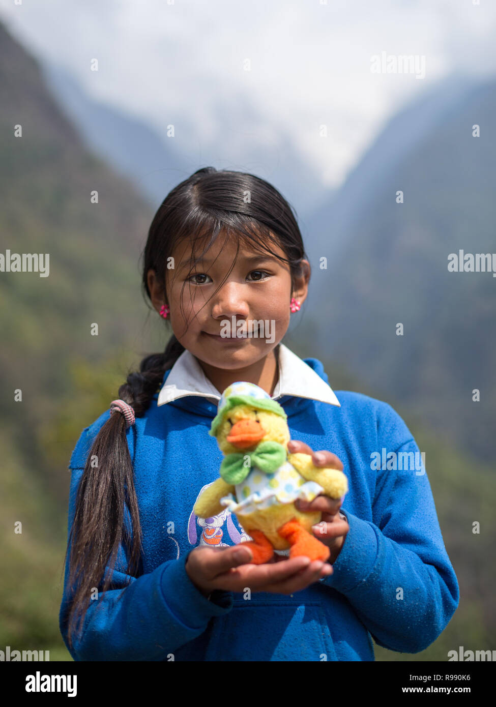 Fille de l'himalaya posent pour l'appareil photo avec doudou et sourire Banque D'Images