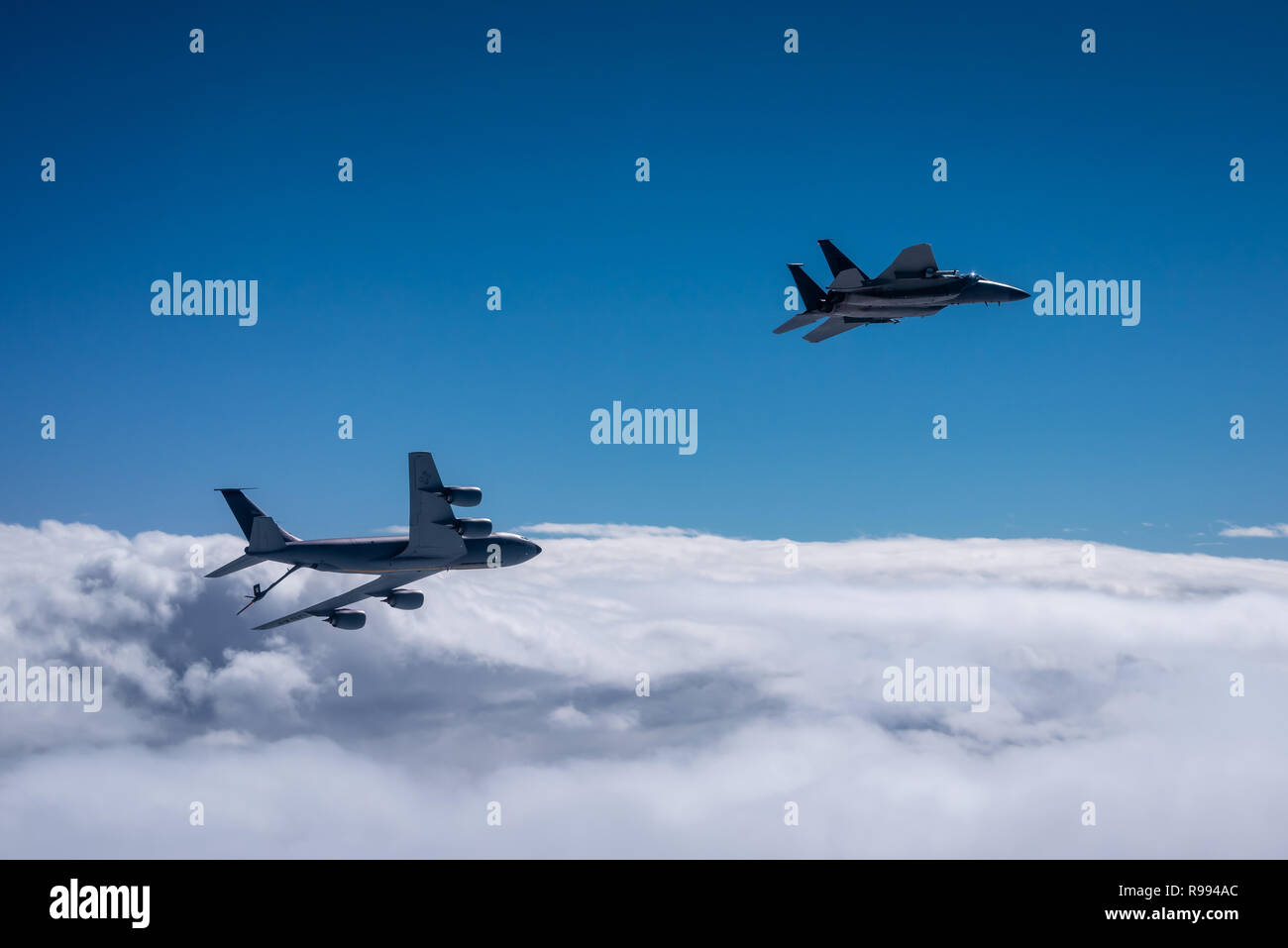 Un KC-135 Stratotanker vole avec un F-15C Eagle sur la mer de Chine orientale, le 11 décembre 2018. Les deux avions sont en provenance d'unités basée à Kadena Air Base, au Japon. Le 909e Escadron de ravitaillement en vol permet d'assurer un ravitaillement en vol de l'Indo-Pacifique en fournissant aux Etats-Unis, alliés et partenaires au sein de la zone de responsabilité. (U.S. Air Force photo par un membre de la 1re classe Matthew Patrick Fougeyrollas) Banque D'Images