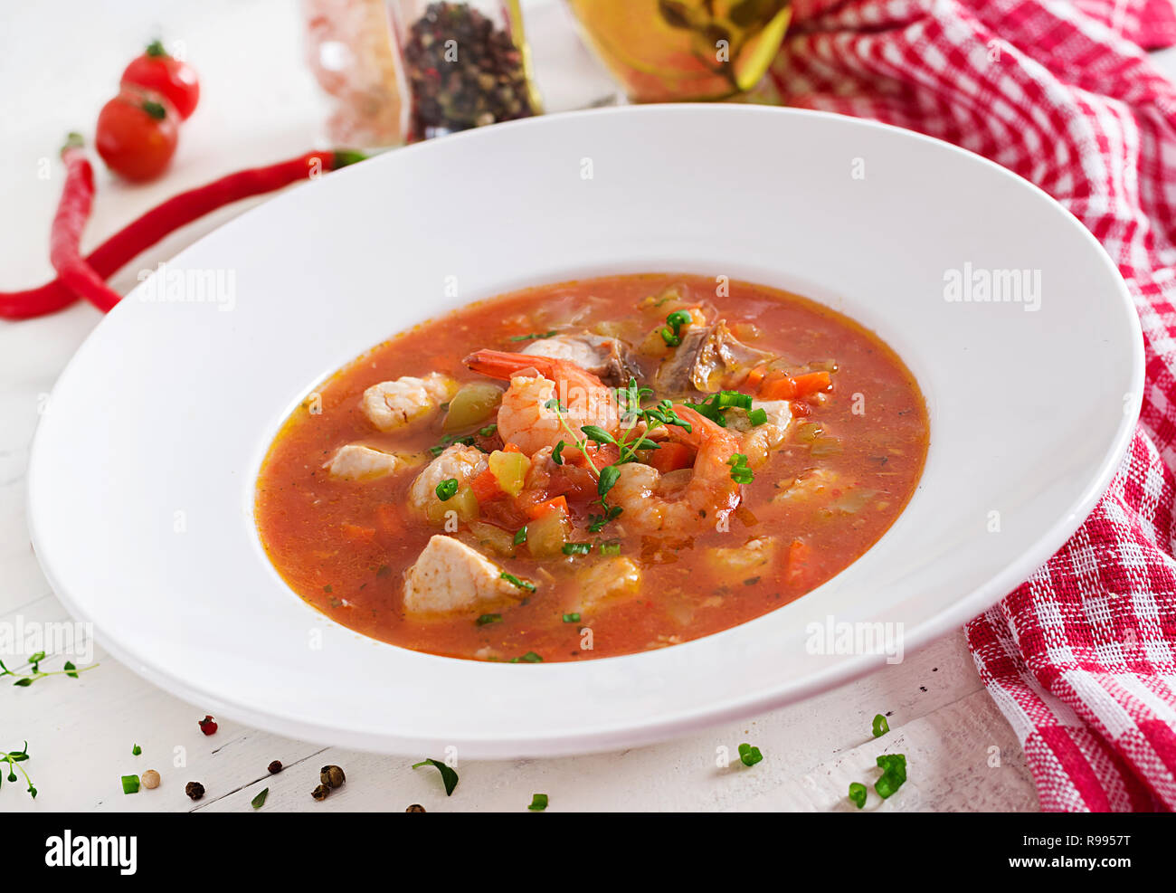 La nourriture brésilienne : Moqueca capixaba de poissons et les poivrons en sauce coco épicé dans une assiette sur une table en bois blanc. Ragoût de poisson brésilien. Banque D'Images