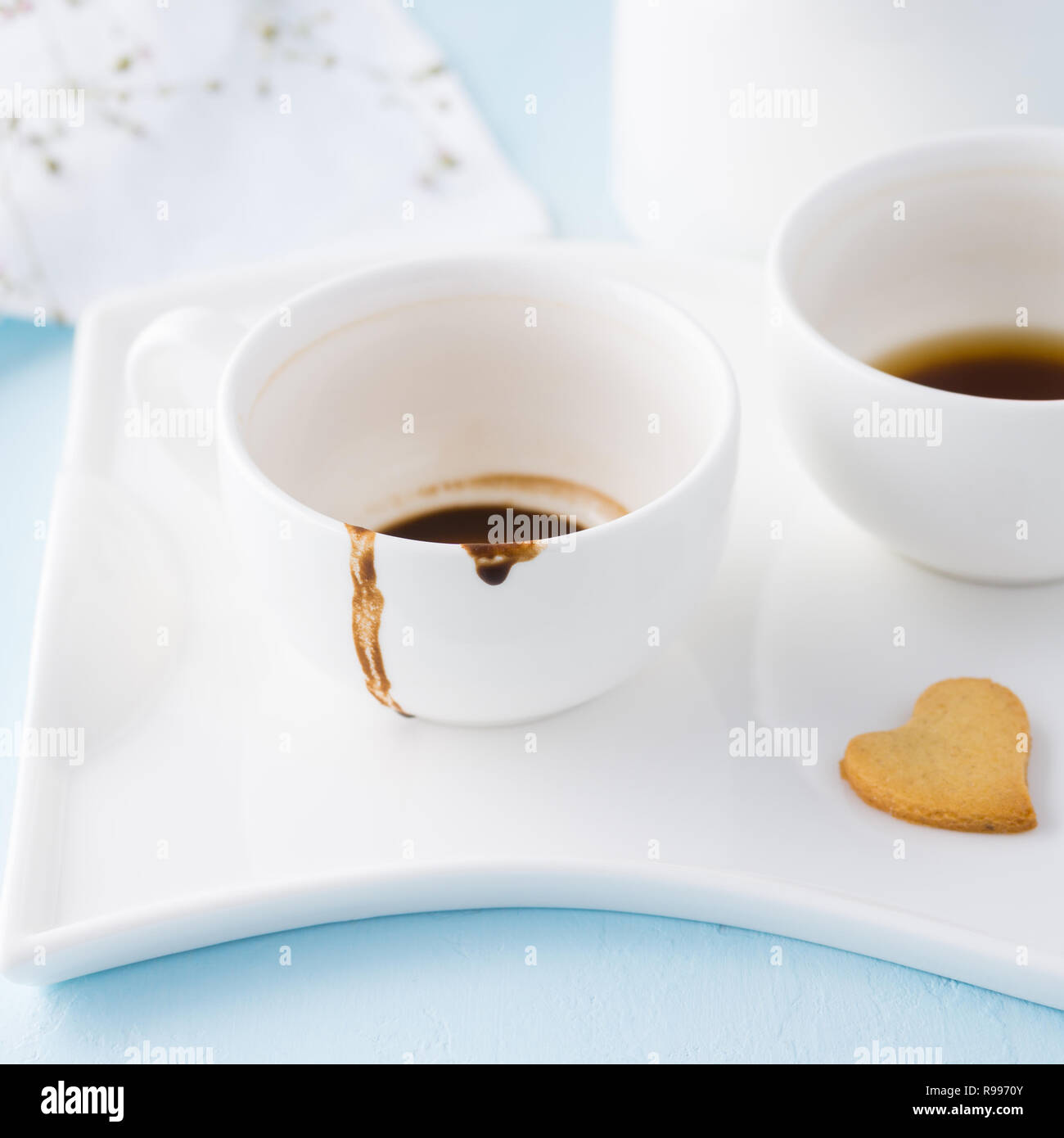 Deux tasses de café vide et en forme d'coeur cookie sur un plateau. Banque D'Images