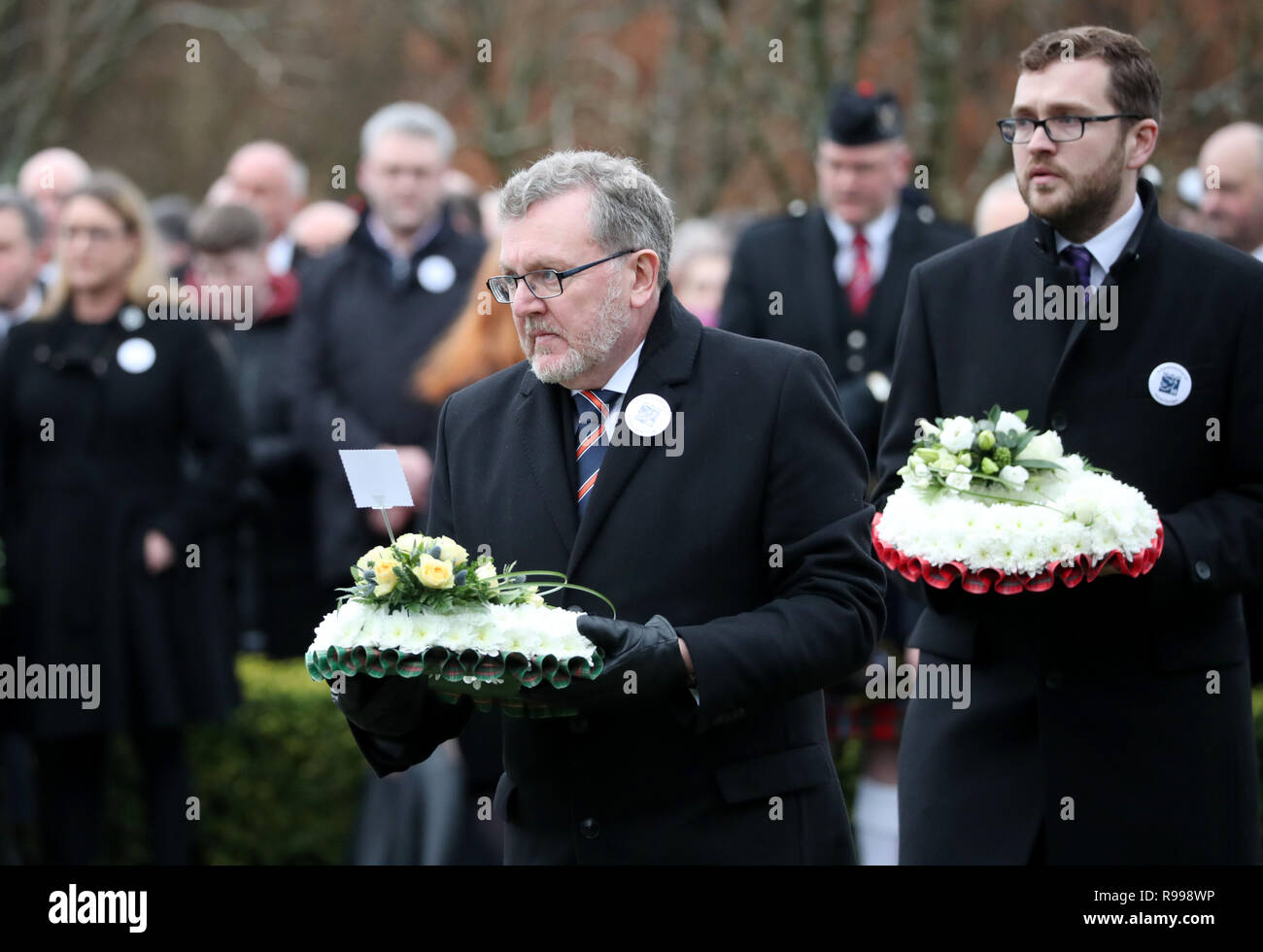 Le Secrétaire écossais David Mundell et son fils Oliver Mundell MSP déposer des couronnes durant la commémoration publique dans le jardin du Souvenir au Cimetière Dryfesdale à Lockerbie pour marquer le 30e anniversaire de l'attentat de Lockerbie. Banque D'Images