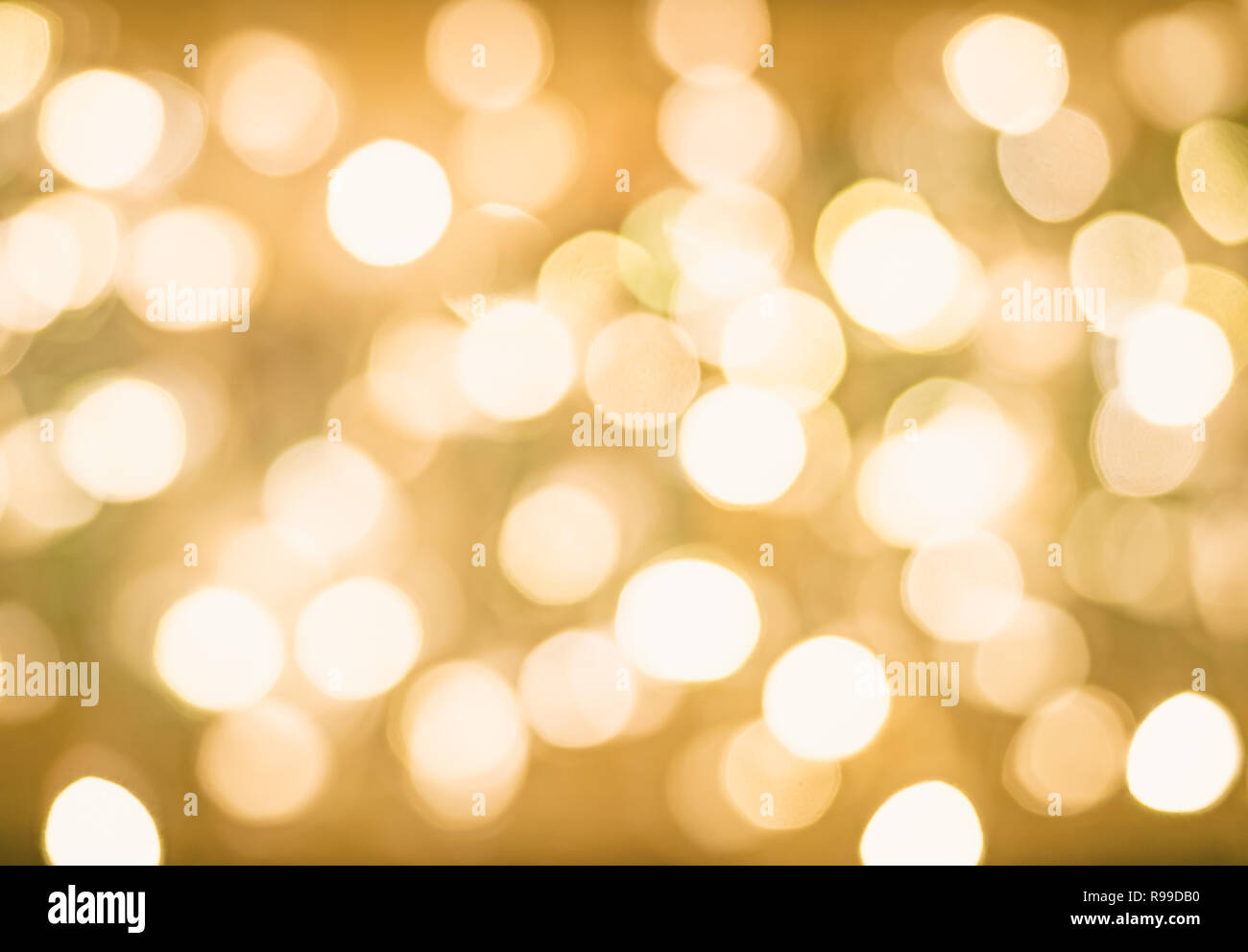 Bokeh flou lumineux Noël fond doré. Lumières de Noël. L'or de vacances Nouvelle Année Résumé Un arrière-plan transparent d'étoiles et d'Étincelles. Banque D'Images