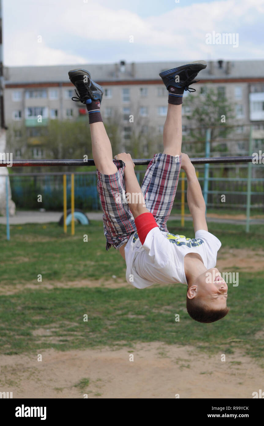 Kovrov, la Russie. 1 mai 2014. L'adolescence est engagé dans gimbarr la discipline sur une barre horizontale dans la cour de l'école Banque D'Images