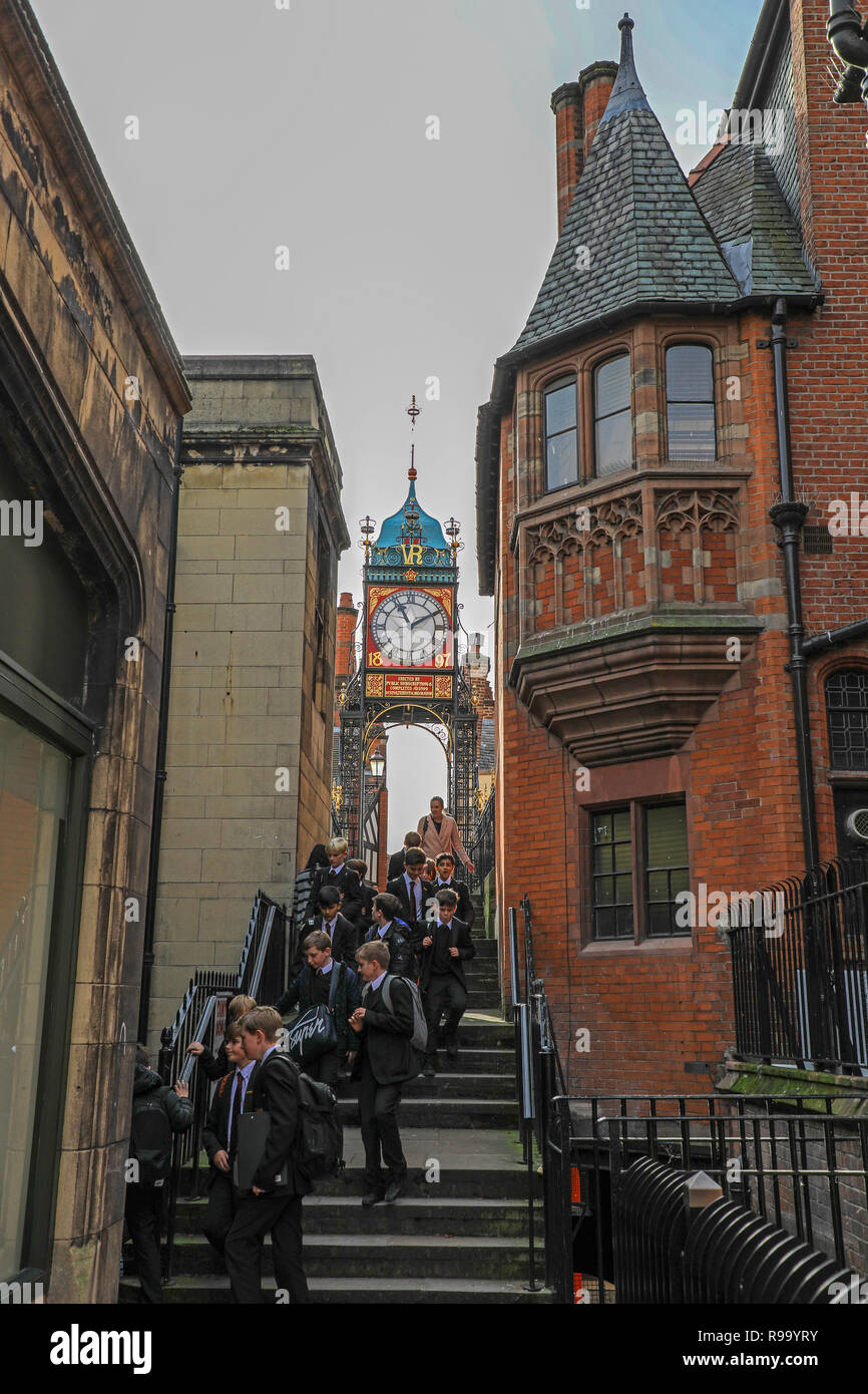 Une partie des enfants de l'école visite de marcher sous l'horloge victorienne sur Newgate, Chester, la ville du comté de Cheshire, England, UK Banque D'Images