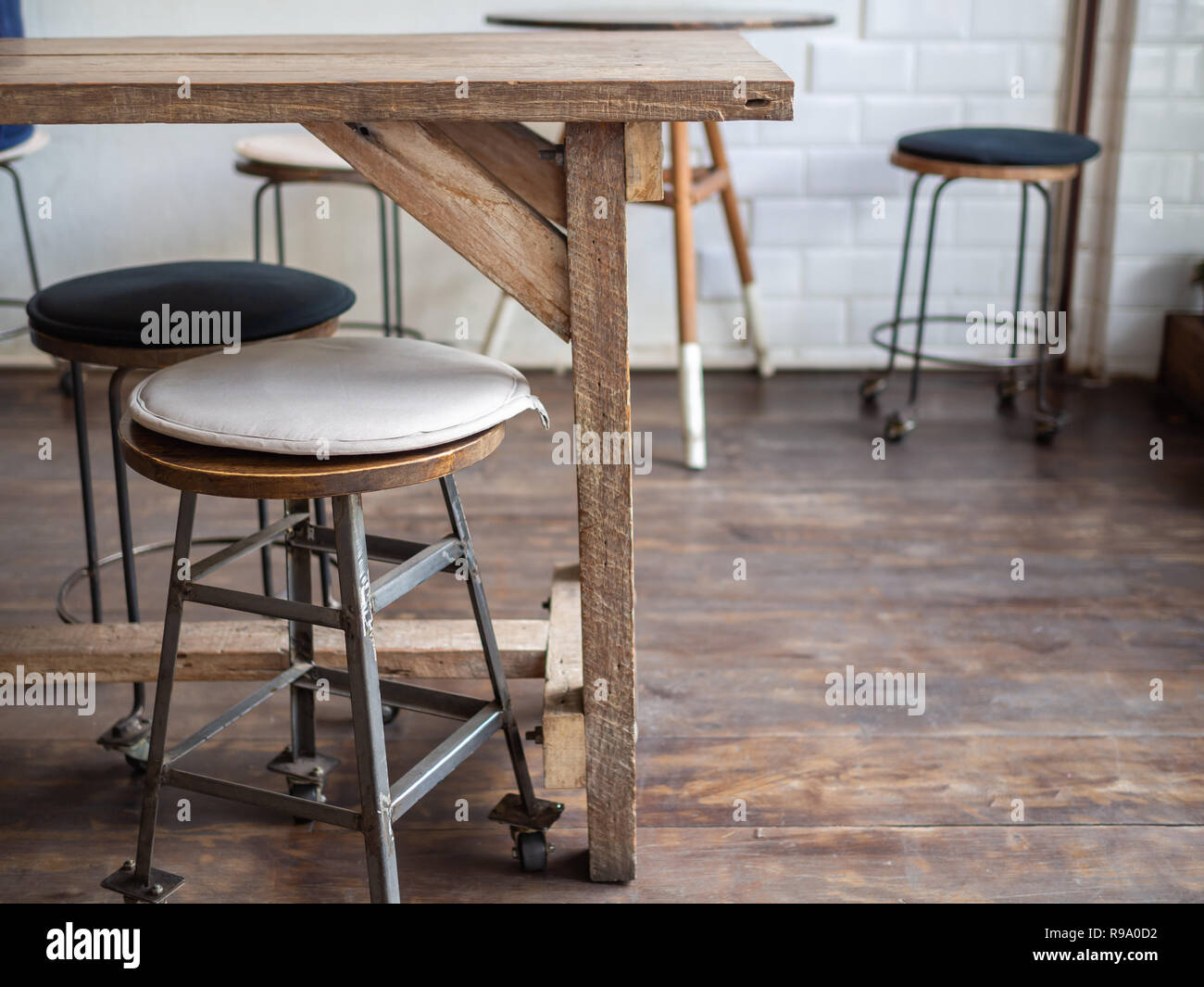 Old vintage tabourets de bar en fer et en bois avec des roues avec tampon  de tissu noir et blanc sur le dessus de table en bois et de parquet dans la