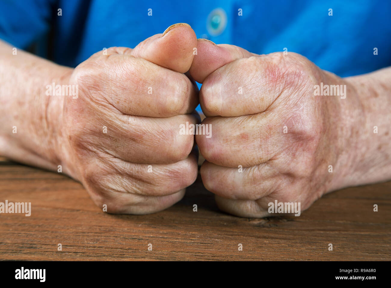 Vieille Femme les mains sur une table rustique vintage Banque D'Images