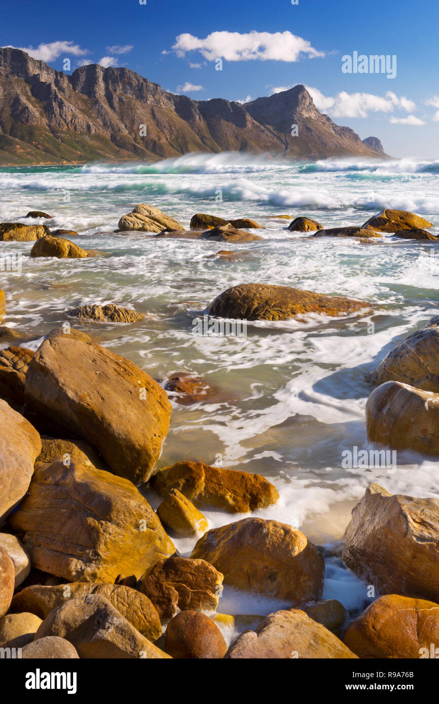 Une plage rocheuse à l'Kogel Bay en Afrique du Sud avec les montagnes de Kogelberg dans le dos. Photographié sur un jour ensoleillé mais très venteux. Banque D'Images