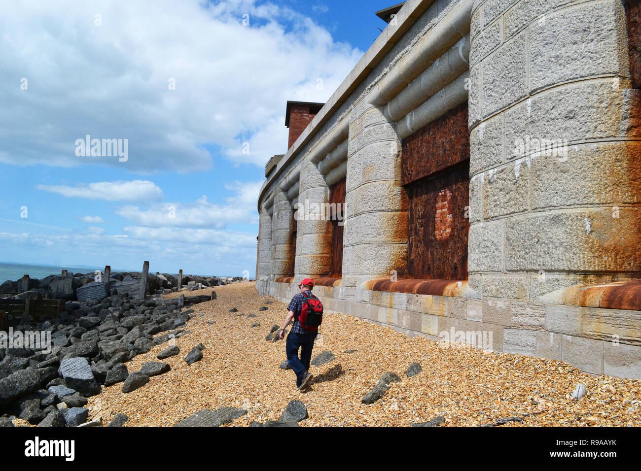 Homme marchant sur la plage à côté de Château de Hurst, Lymington, New Forest, Hampshire, Royaume-Uni Banque D'Images