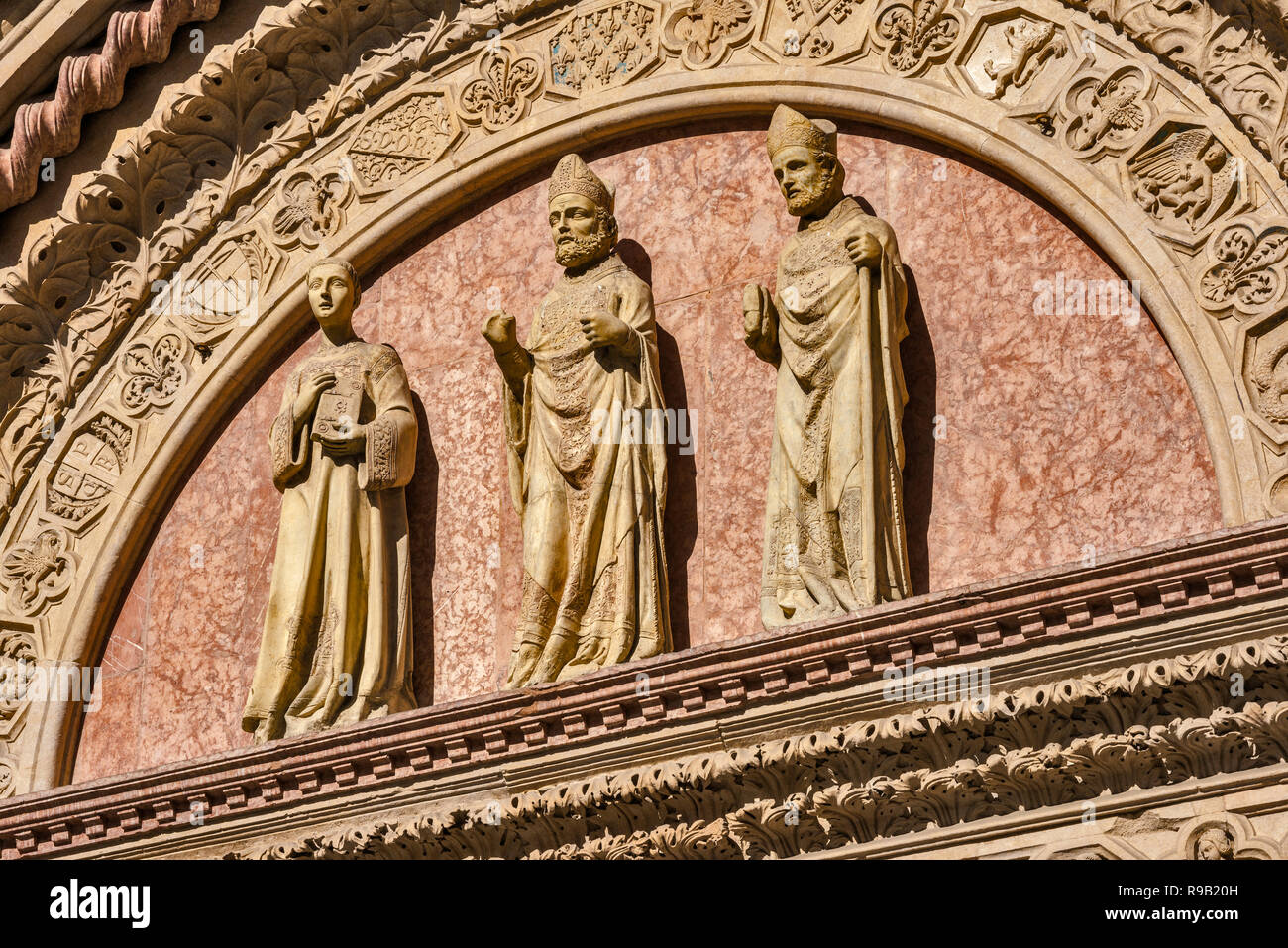 Statues de Saint Louis, St Laurent et St Herculanus au tympan, Galleria Nazionale dell'Umbria, Le Palais des Prieurs à Pérouse, Ombrie, Italie Banque D'Images