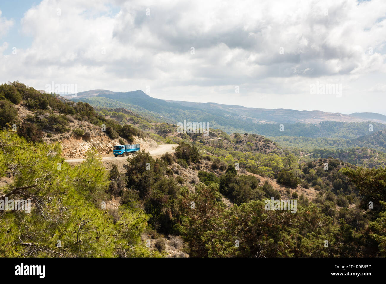 Petit camion bleu roulant sur une petite route de gravier et sinueuse dans péninsule d'Akamas, à Chypre. Banque D'Images