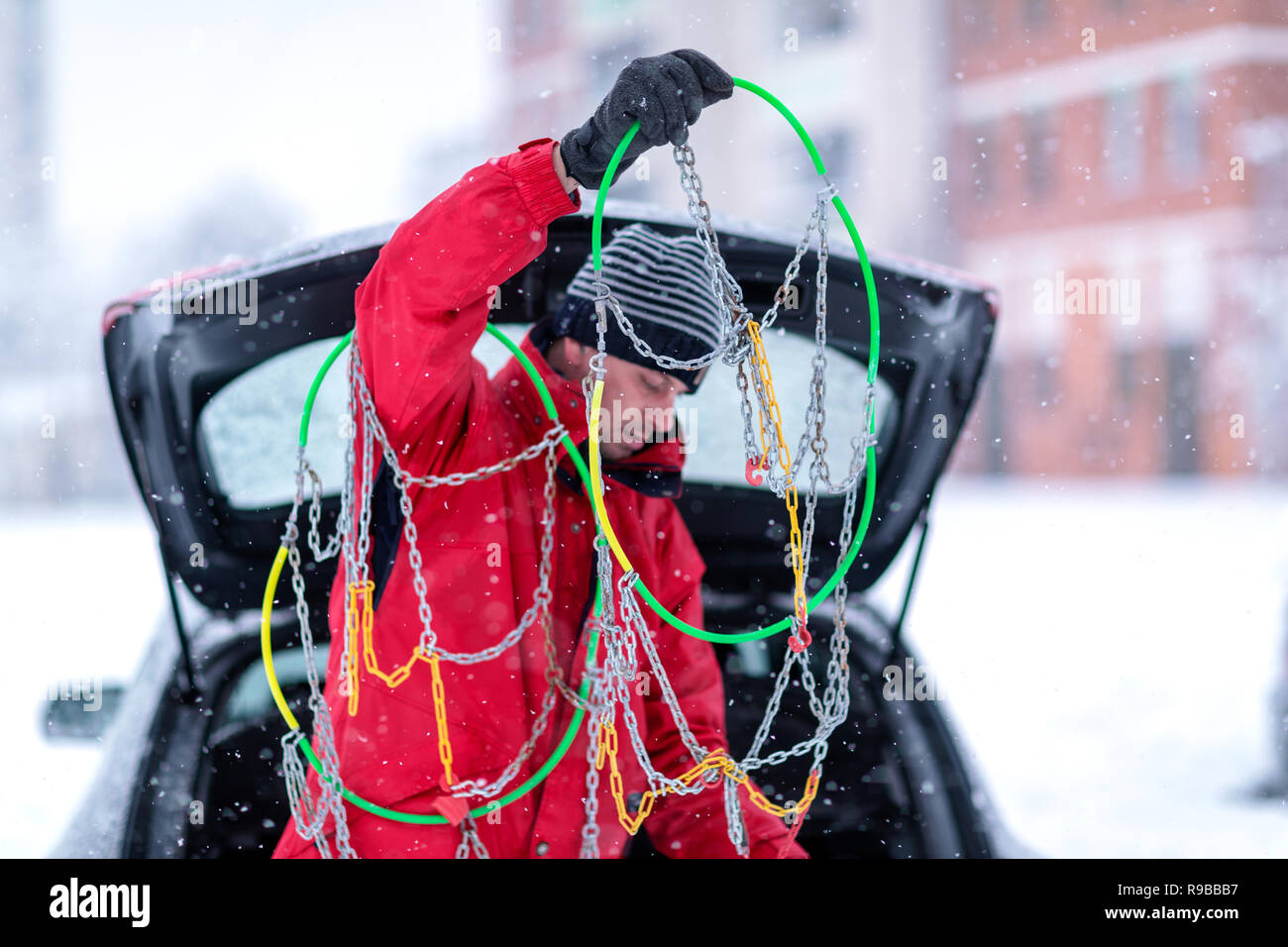 Jeune homme avec des chaînes pour pneus neige voiture ventilation Banque D'Images