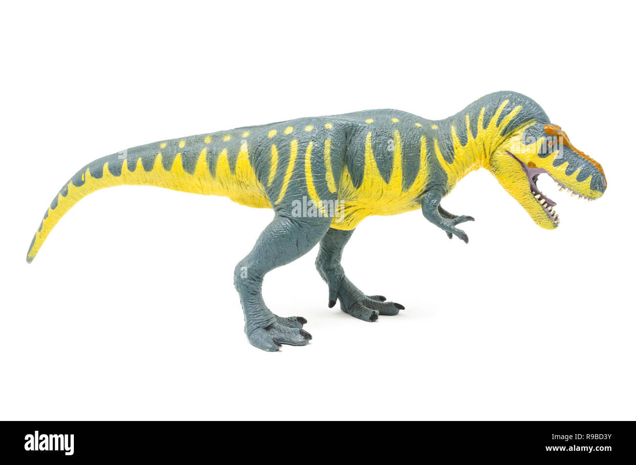 Vue latérale du jaune bleu Battat Tyrannosaurus rex dinosaur toy, isolé sur un fond blanc. Banque D'Images