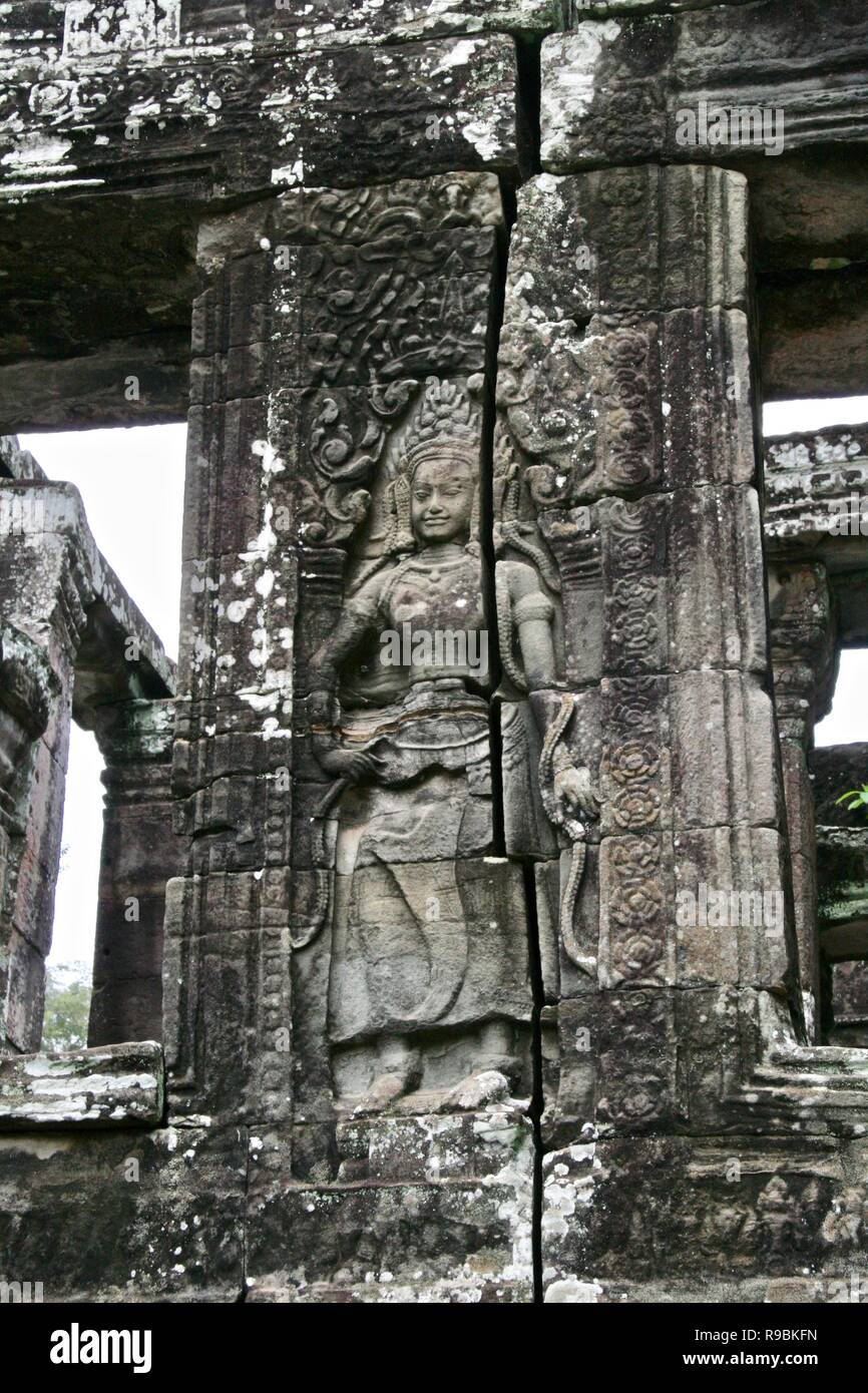 Une danseuse sculptée dans un pilier en pierre à l'intérieur des ruines de la jungle au Cambodge Banque D'Images