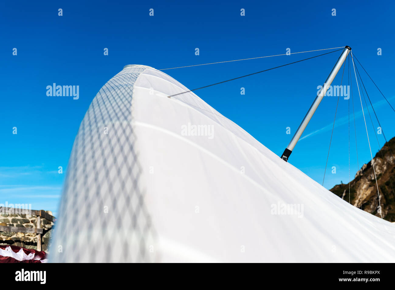Vue grand angle avec une faible profondeur de champ sur la surface d'un voile de cerf-volant blanc contre un ciel bleu estival sur le Tegelberg en Bavière. La f Banque D'Images