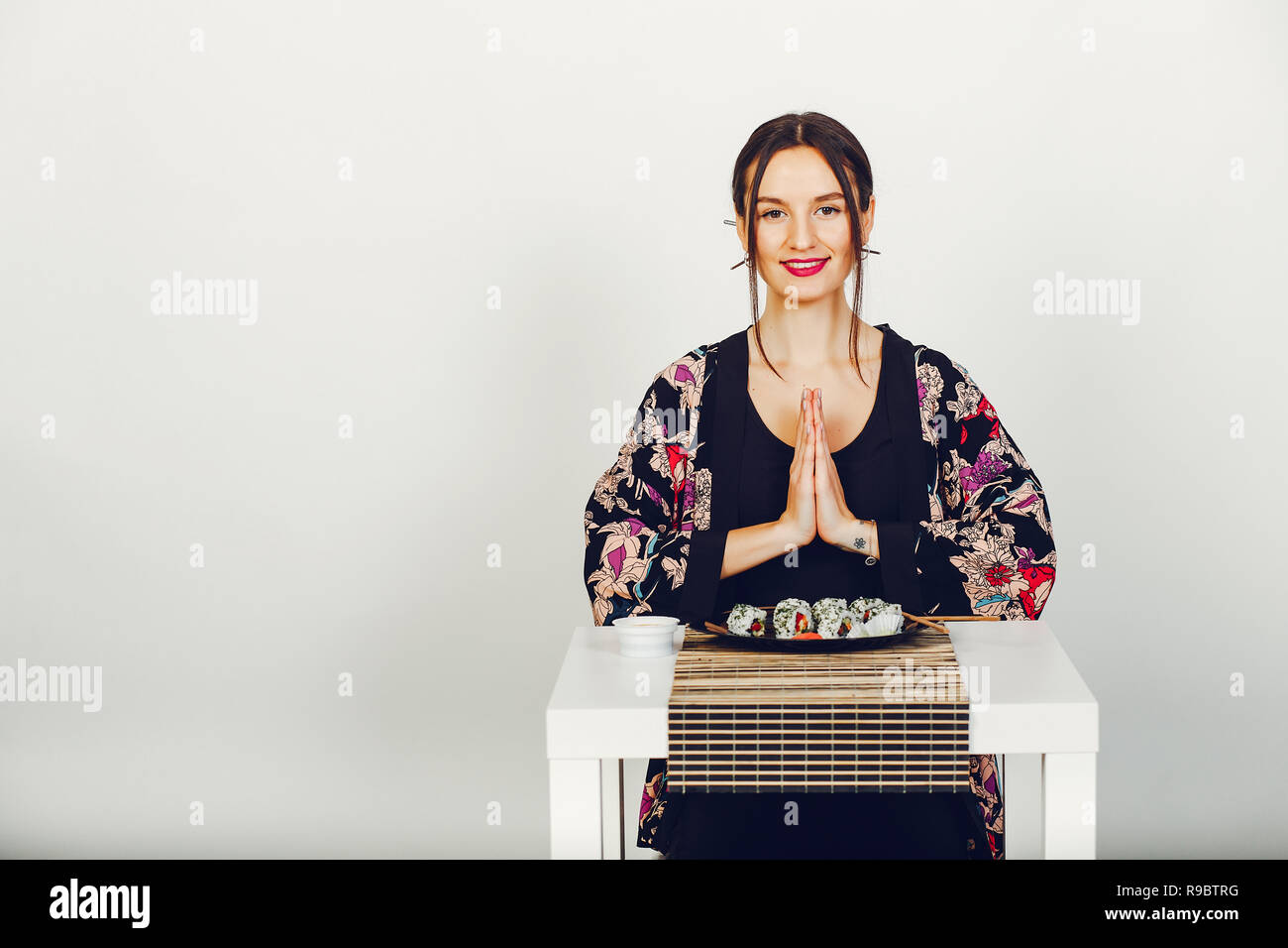 Belle fille manger un sushi dans un studio Banque D'Images