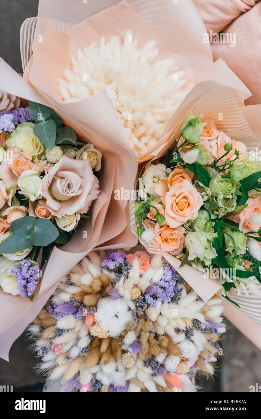 Bouquet coloré de différentes fleurs séchées Fleurs de bois mort dans les mains d'un fleuriste femme. Fond de fleurs rustiques. Bouquet de fleurs artisanales. Banque D'Images