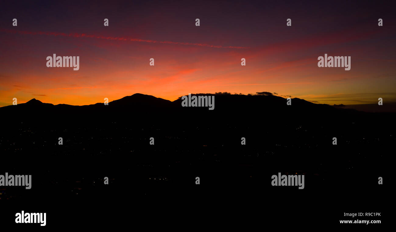 Vue aérienne d'un spectaculaire coucher de soleil derrière quelques belles montagnes en Italie. Banque D'Images