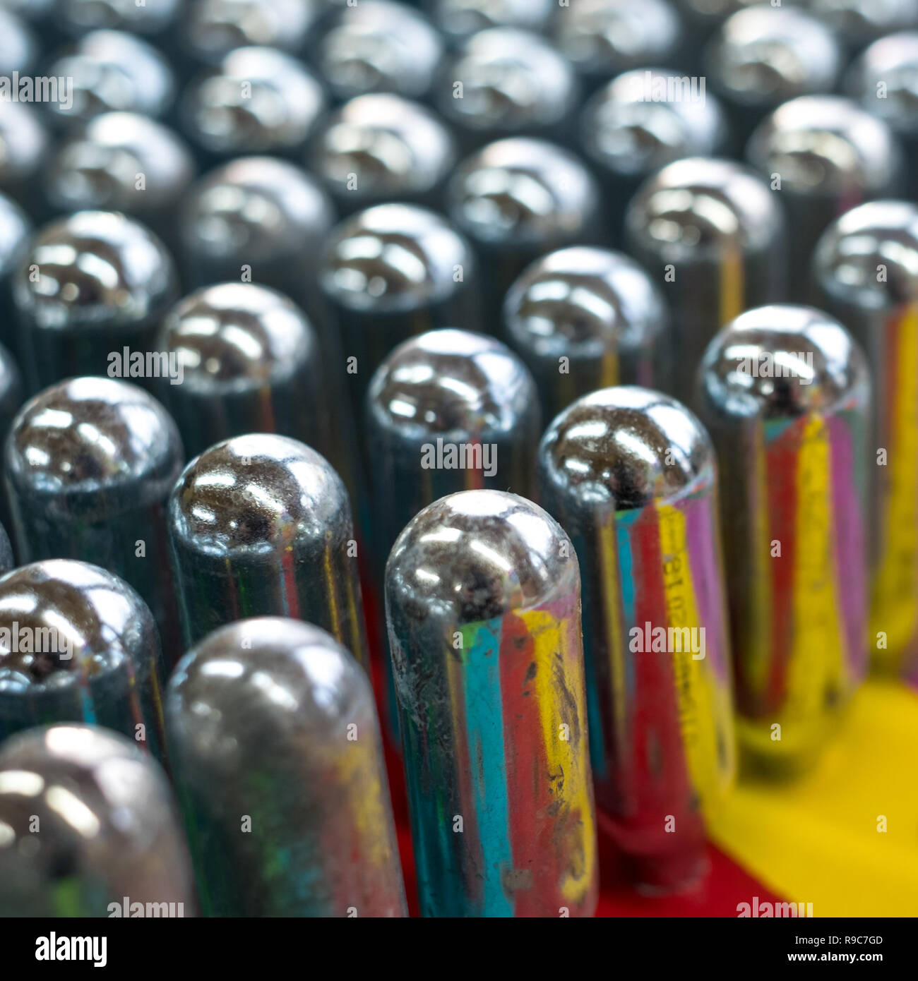 L'oxyde nitreux cannisters vide reflétant couleurs psychédéliques : cylindres de métal contenant de l'oxyde nitreux, utilisé pour la crème à fouetter, mais aussi comme un cadre juridique Banque D'Images