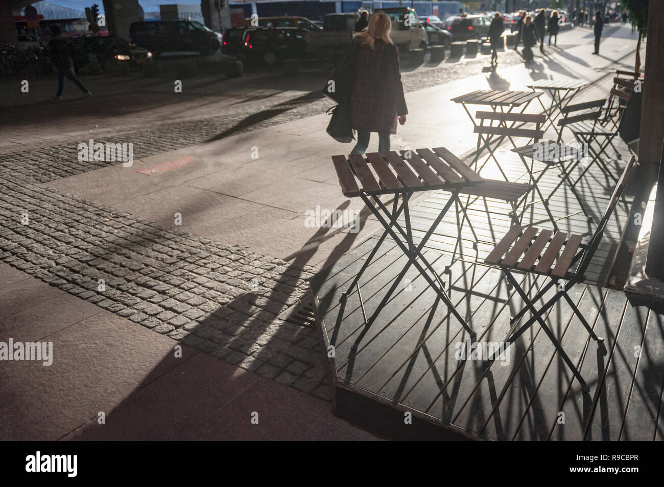 Les ombres des peuples et des chaises que les figures graphiques sur le sol en début de matinée, Stockholm, Suède. Banque D'Images