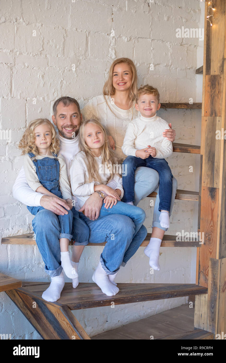 Happy Family sitting sur l'escalier à la maison. Banque D'Images