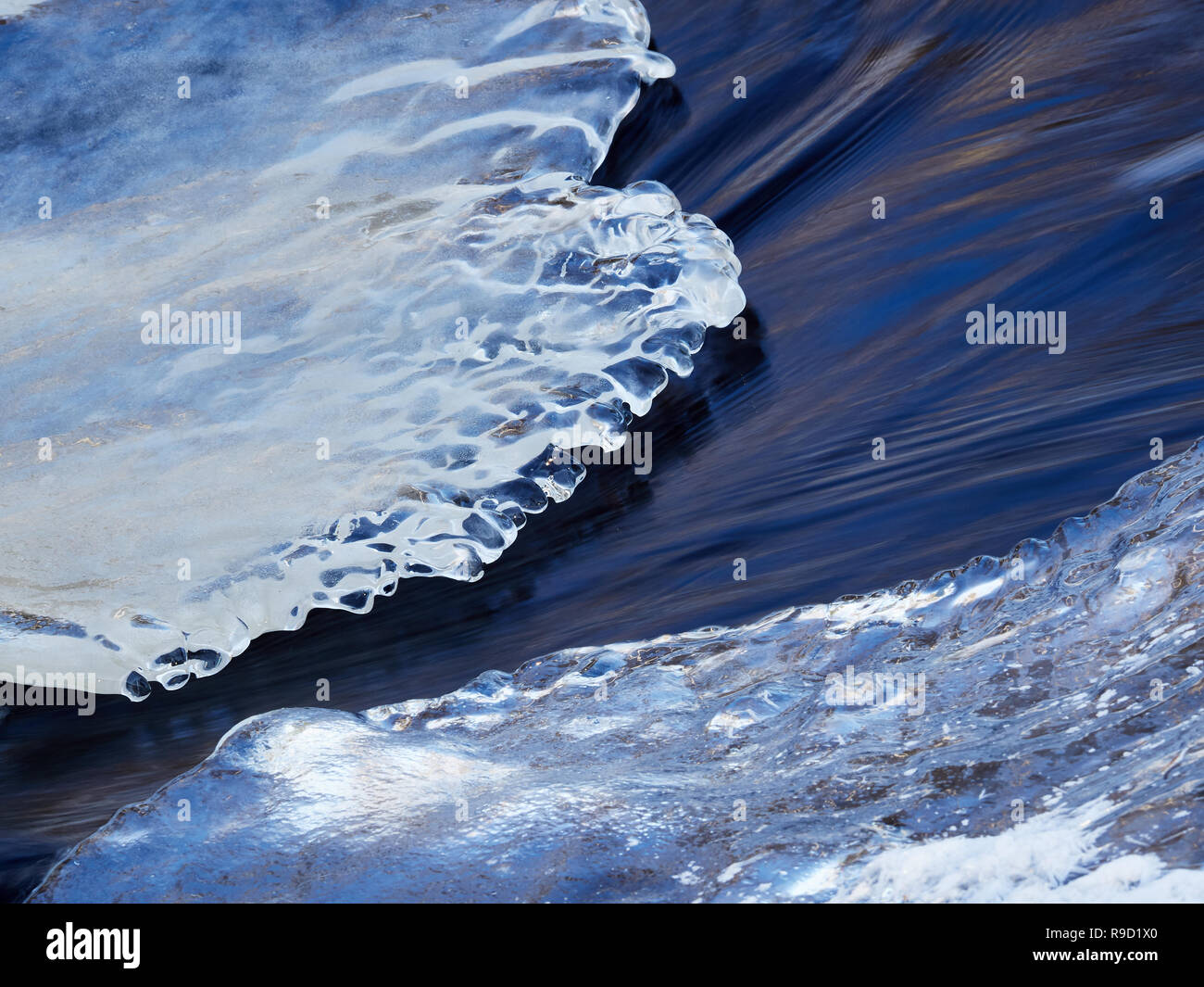 Rivière gelée enrobé de glace avec le givre et la neige avec la diffusion d'eau en hiver. Banque D'Images Rivière gelée enrobé de glace avec le givre et la neige avec la diffusion d'eau en hiver. Banque D'Images
