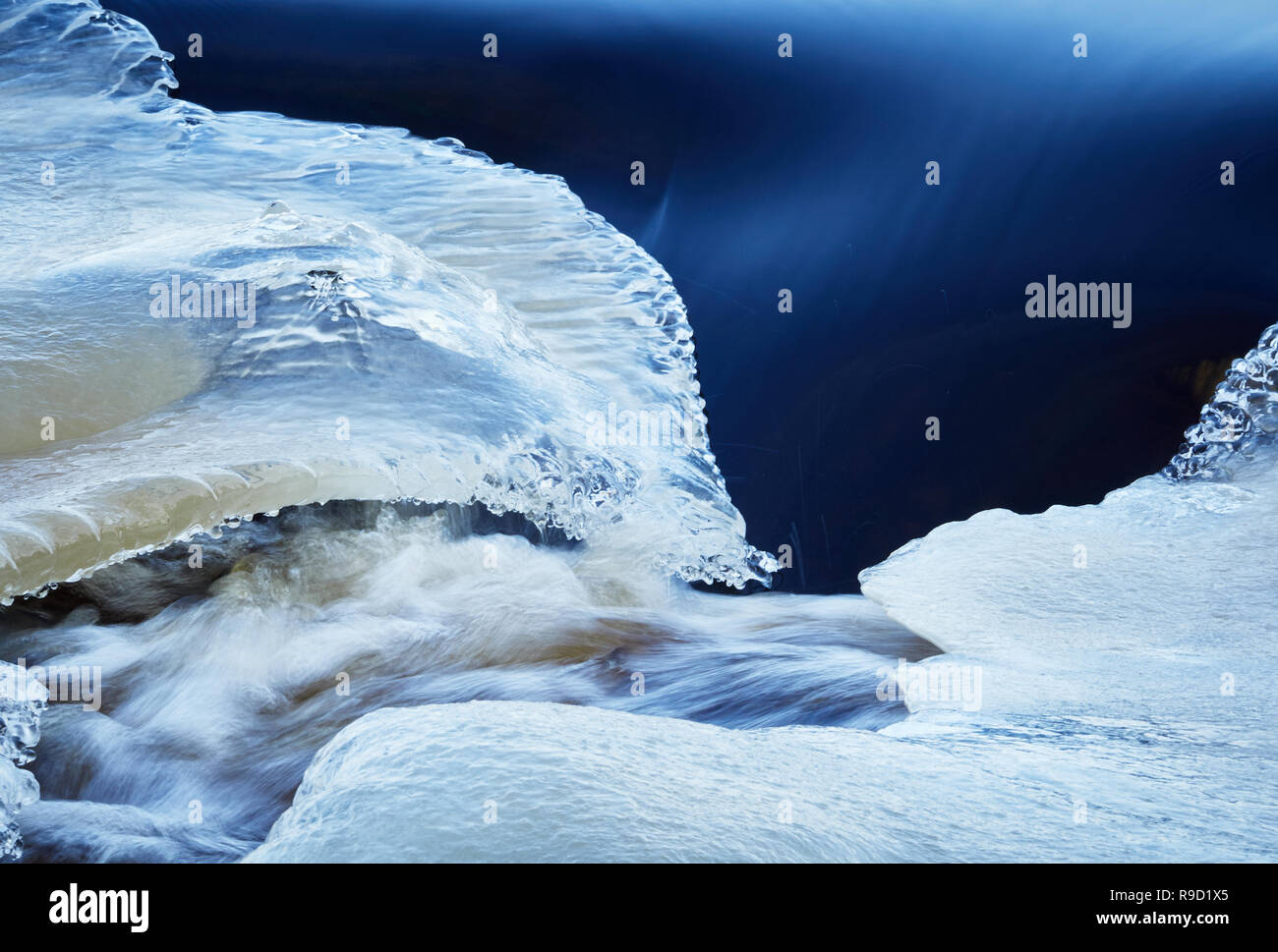 Rivière gelée enrobé de glace avec le givre et la neige avec la diffusion d'eau en hiver. Banque D'Images Rivière gelée enrobé de glace avec le givre et la neige avec la diffusion d'eau en hiver. Banque D'Images