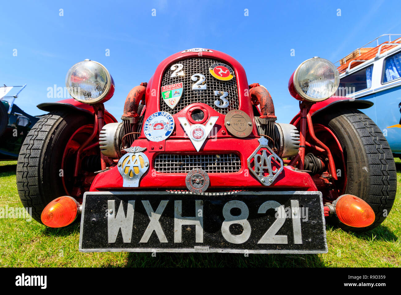Lomax 223 type vintage, construire l'auto voiture. Angle de vue large, peu de couleur rouge avant de voiture avec grille de radiateur couvert dans divers badges auto. Contexte Banque D'Images