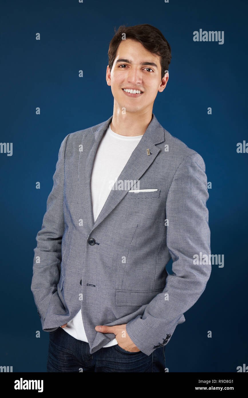 Happy smiling young hispanic man isolé sur fond bleu studio Banque D'Images