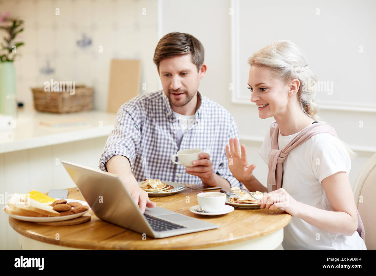 Couple talking par liaison vidéo pendant le petit-déjeuner Banque D'Images