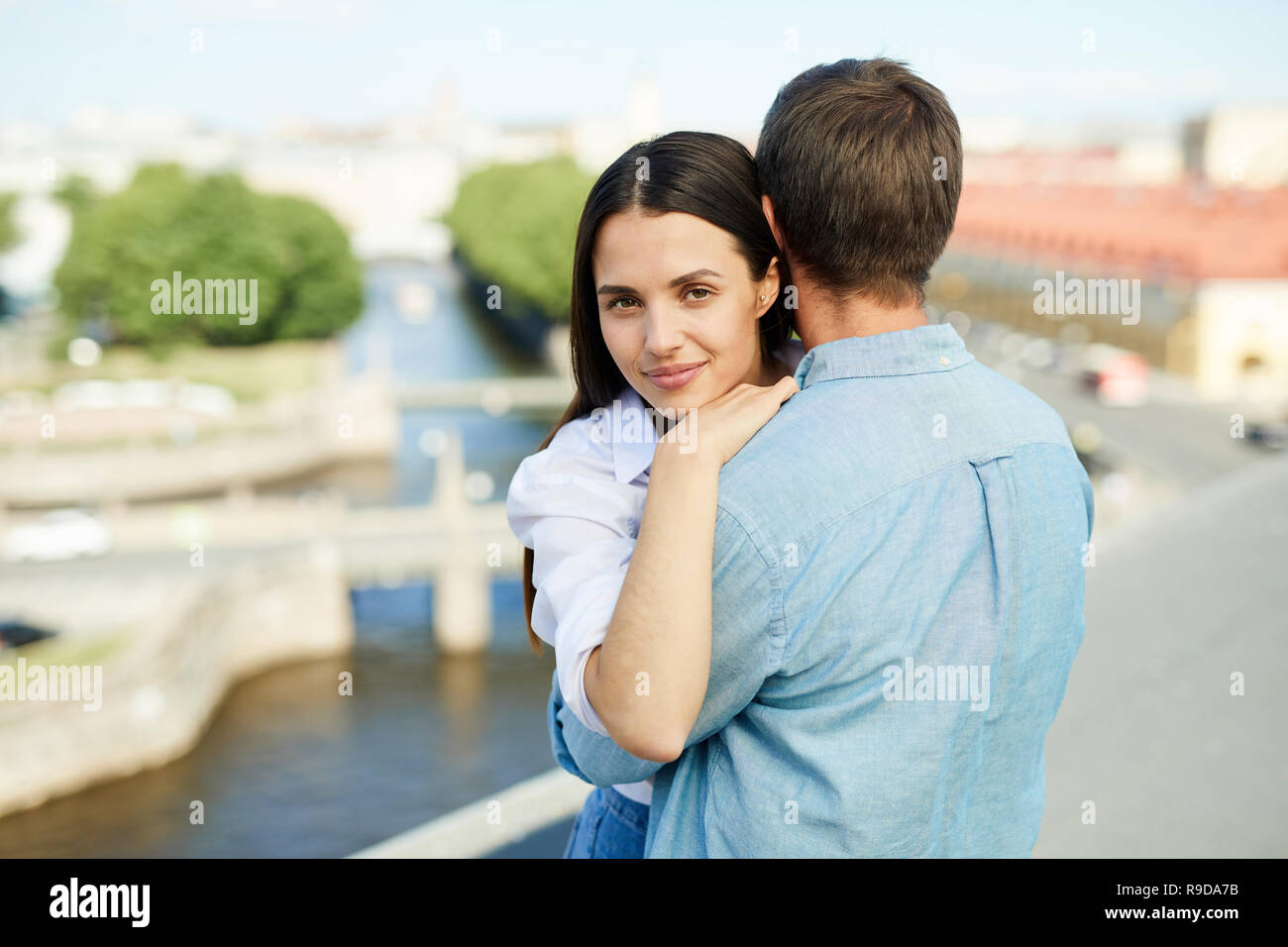 Jolie jeune fille contenu embrassant copain sur le toit Banque D'Images