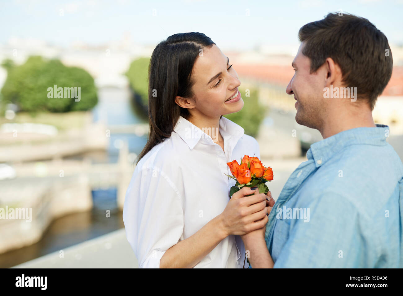 Homme heureux donnant des fleurs pour petite amie Banque D'Images