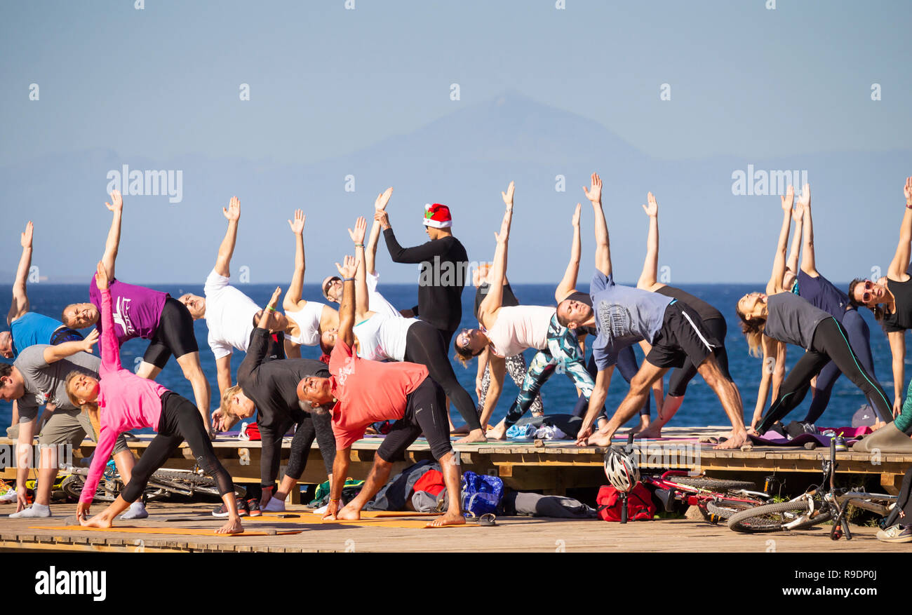 Las Palmas, Gran Canaria, Îles Canaries, Espagne. Dec 22, 2018. Météo : Noël avant séance de yoga sur la plage de Las Palmas de Gran Canaria sur une glorieuse samedi dans les îles Canaries, où des milliers de vacanciers du Royaume-Uni sera la position de certains soleil d'hiver à Noël. Sur la photo : la plus haute montagne d'Espagne, El Teide (3,178m) sur Ténérife (environ 50 milles) visible en arrière-plan. Credit : ALAN DAWSON/Alamy Live News Banque D'Images
