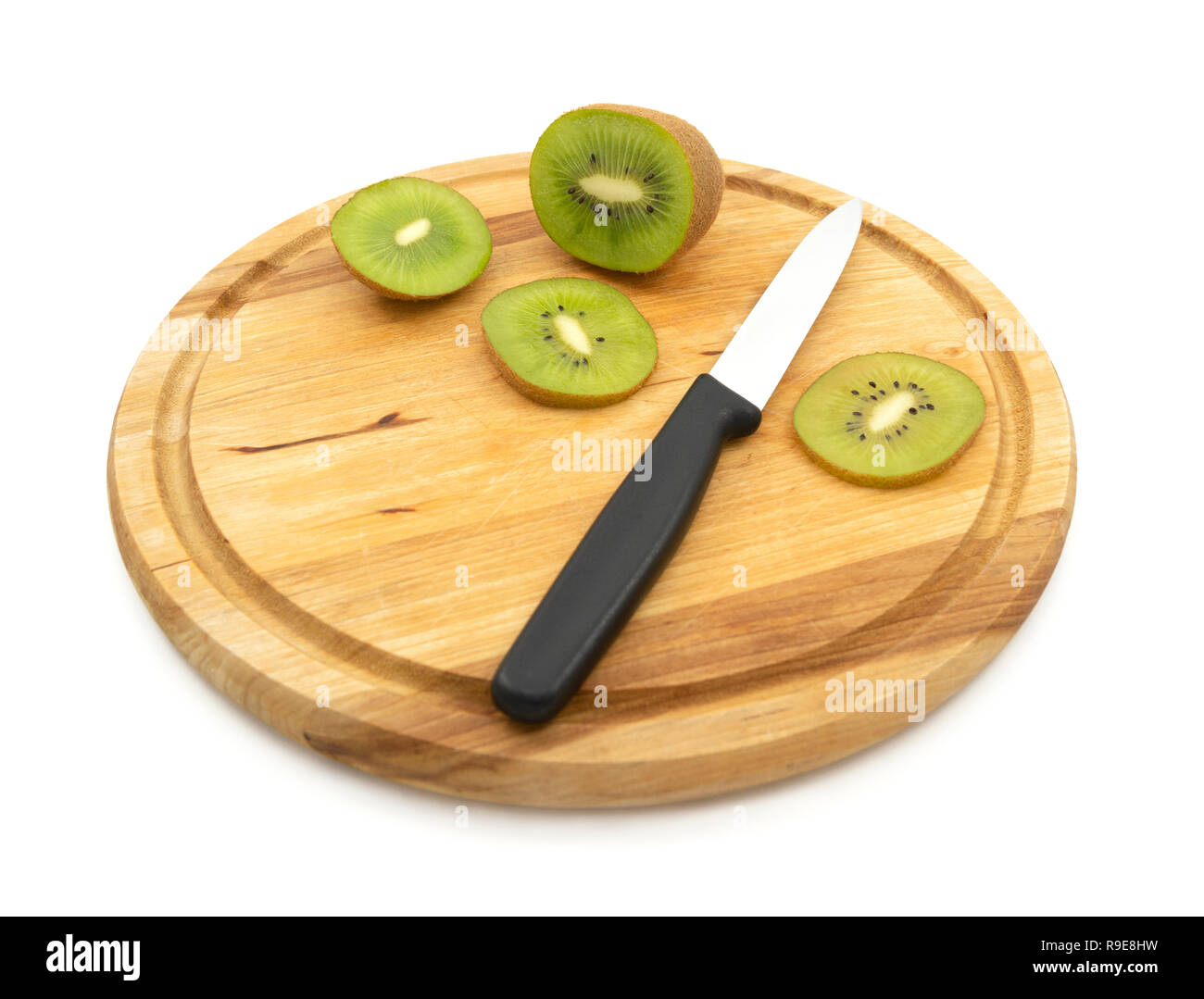 Couteau de cuisine utilisé pour couper des tranches de kiwi, montrant péricarpe vert et les graines noires Banque D'Images