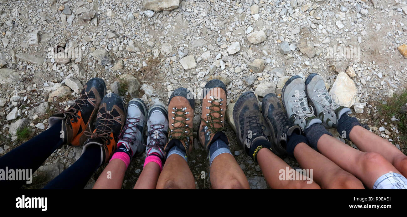 Les jambes et les bottes d'une famille de 5 avec 3 enfants se reposant après la randonnée dans les montagnes Banque D'Images