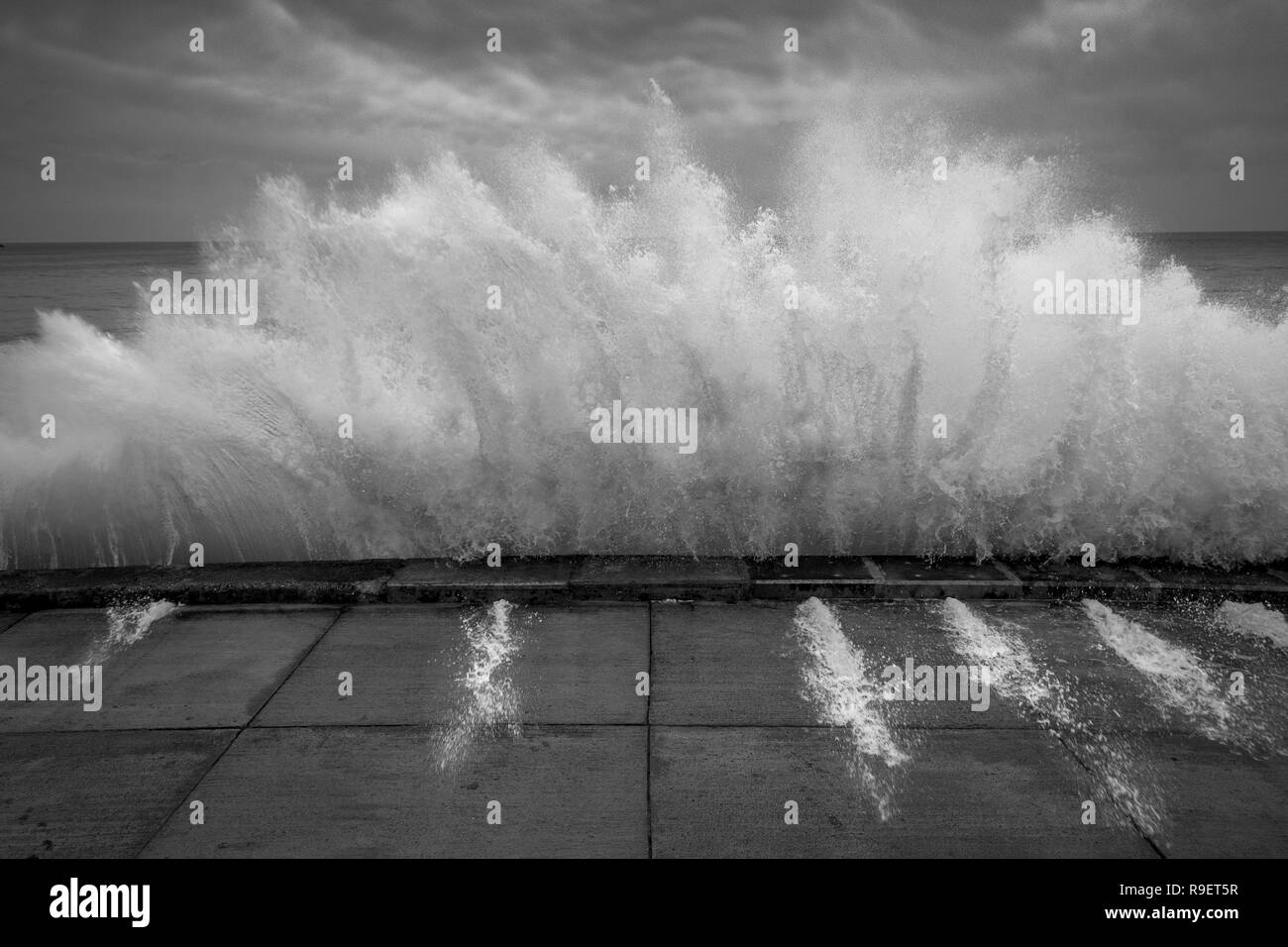 Front de Scarborough : Dramatique vague s'écraser contre le mur de la mer en noir et blanc Banque D'Images