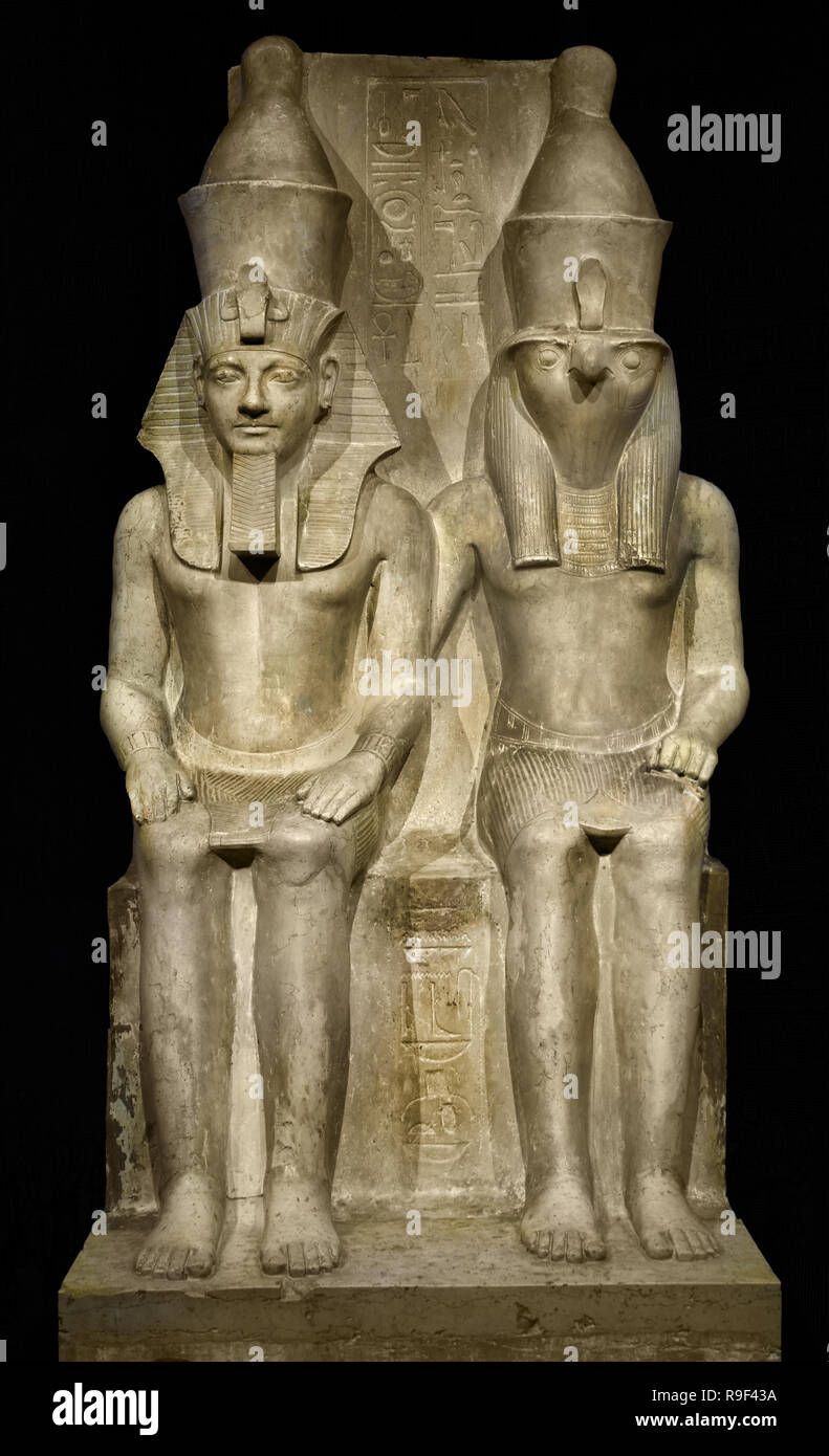 Droit d'Horus et d'Horemheb ce temple image représente le dieu Horus et le pharaon égyptien Horemheb (1319-1305 BC) assis côte à côte. Horus porte une tête de comme une puissance céleste. Le roi est de la même taille que le dieu, car selon les Égyptiens il est tout aussi puissant. Il est l'apparence terrestre d'Horus et ainsi lui-même un dieu. (1,52 mètres de calcaire : Nouvel Empire, xviiie dynastie (1319-1305 avant J.-C.) L'Égypte, l'Égyptien. Banque D'Images