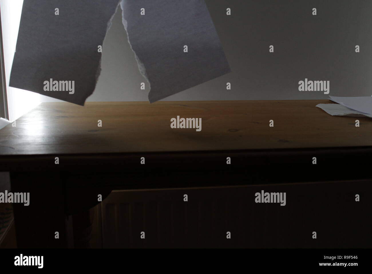 Papier blanc déchiré dans la moitié sur un bureau en bois clair format paysage Banque D'Images