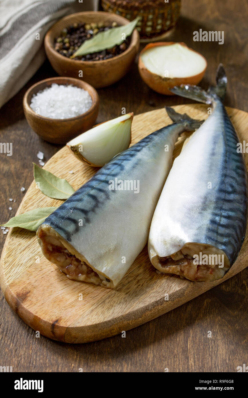Le poisson frais. La cuisson du poisson ingrédients pour la marinade. Le maquereau avec sel et épices sur une table en bois. Banque D'Images