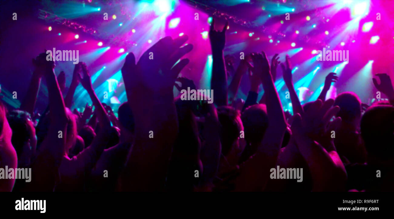 Une foule de spectateurs à un concert applaudi leurs mains vers le haut. Les gens dans la red de rampes. L'image floue pour l'arrière-plan Banque D'Images