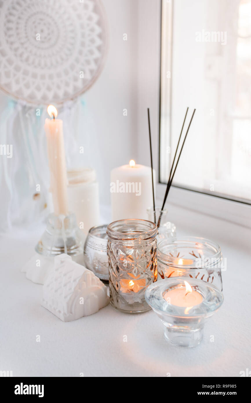 Une très belle décoration de verre blanc des bougies allumées dans des  chandeliers debout sur rebord de la beauté, l'endroit dans la maison,  concept d'weekena ou une maison de vacances confortable d'hiver
