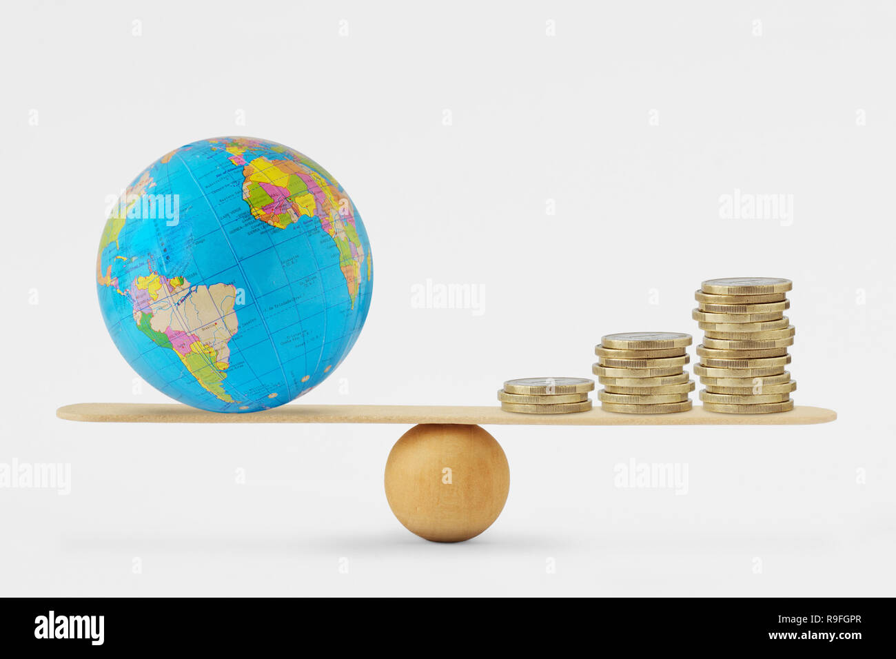 Globe terrestre et de l'échelle d'équilibre de la pile de pièces - Notion d'équilibre entre la santé et la croissance économique planétaire Banque D'Images