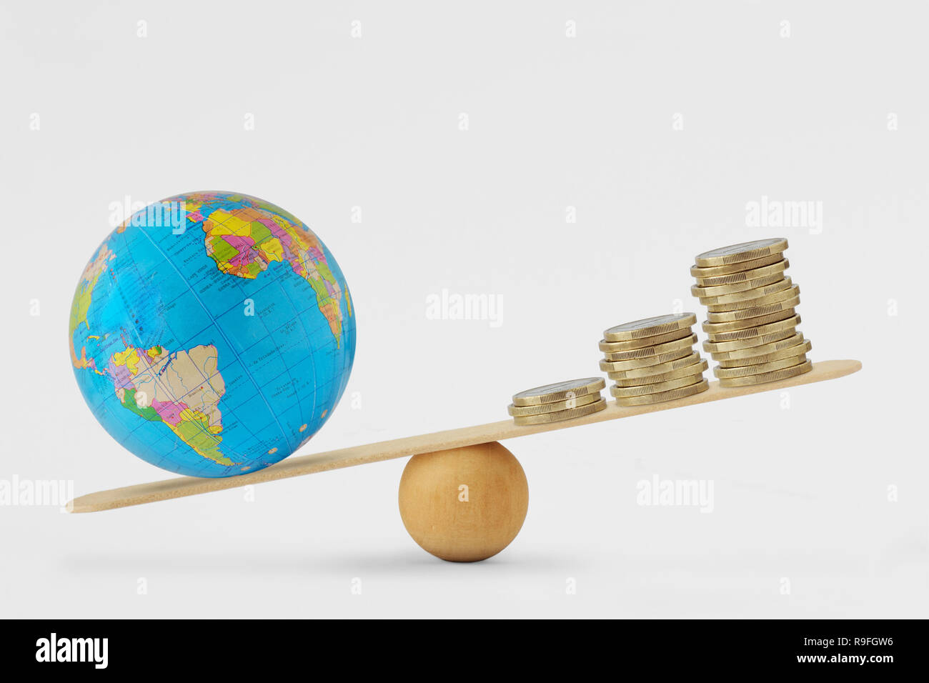 Globe terrestre et de l'échelle d'équilibre de la pile de pièces - concept de santé planétaire la priorité sur la croissance économique Banque D'Images