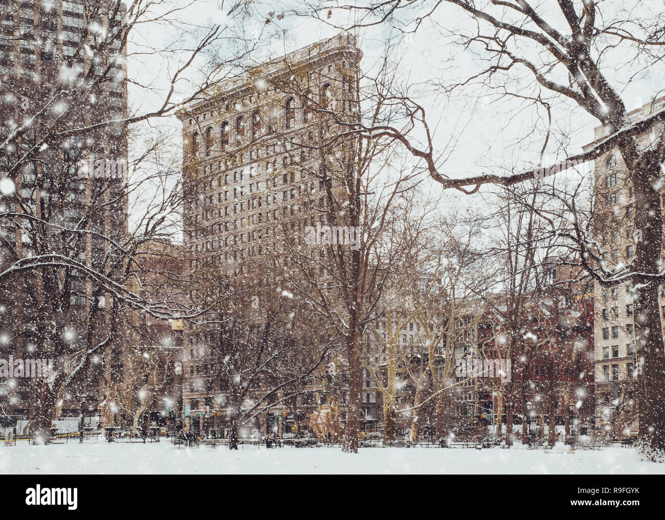 Voir l'historique de Flatiron building de Madison Square Park de New York Midtown Manhattan, avec des flocons de neige tombant pendant la tempête de neige Banque D'Images