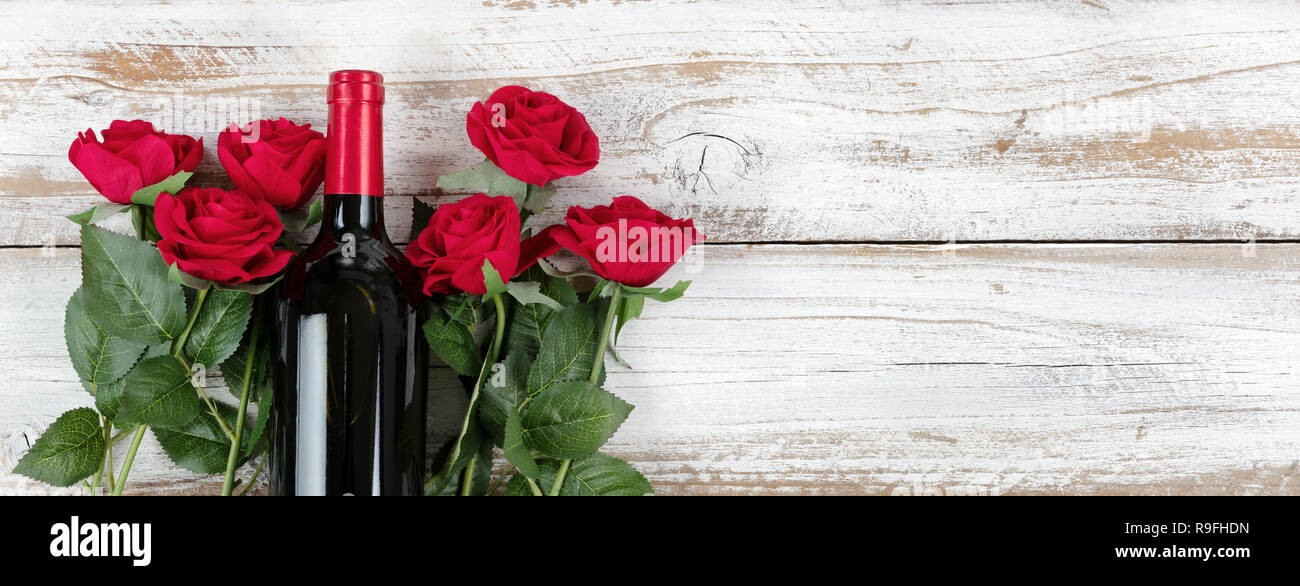 Saint Valentin romantique célébration avec vin rouge et roses sur fond blanc en bois rustique Banque D'Images
