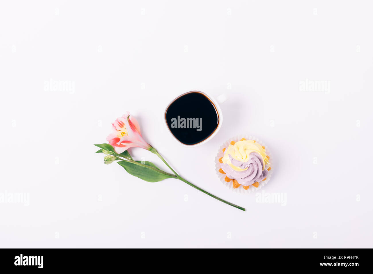 Télévision avec cupcake composition laïcs tasse de café et de fleurs roses sur fond blanc, vue du dessus. Banque D'Images