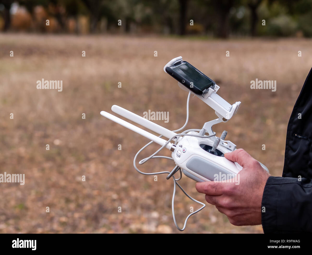 Un pilote de drone piloter avec la télécommande avec le smartphone dans ses  mains dans la forêt Photo Stock - Alamy