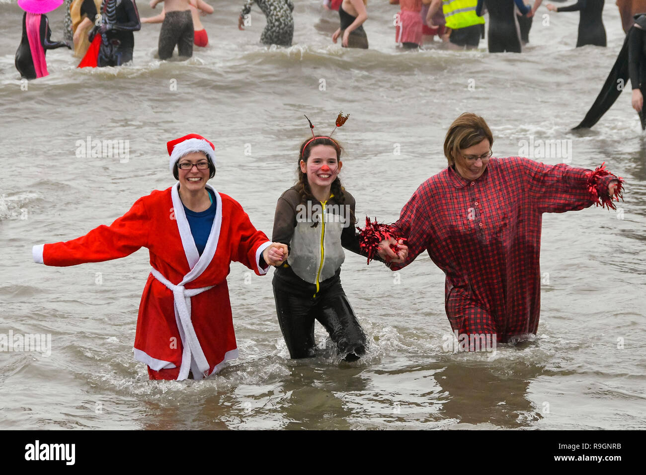 Charmouth, Dorset, UK. Dec 25, 2018. Le jour de Noël des nageurs portant robe de braver l'eau froide pour se rafraîchir dans la mer à Charmouth dans Dorset pour recueillir des fonds pour la RNLI. Crédit photo : Graham Hunt/Alamy Live News Banque D'Images